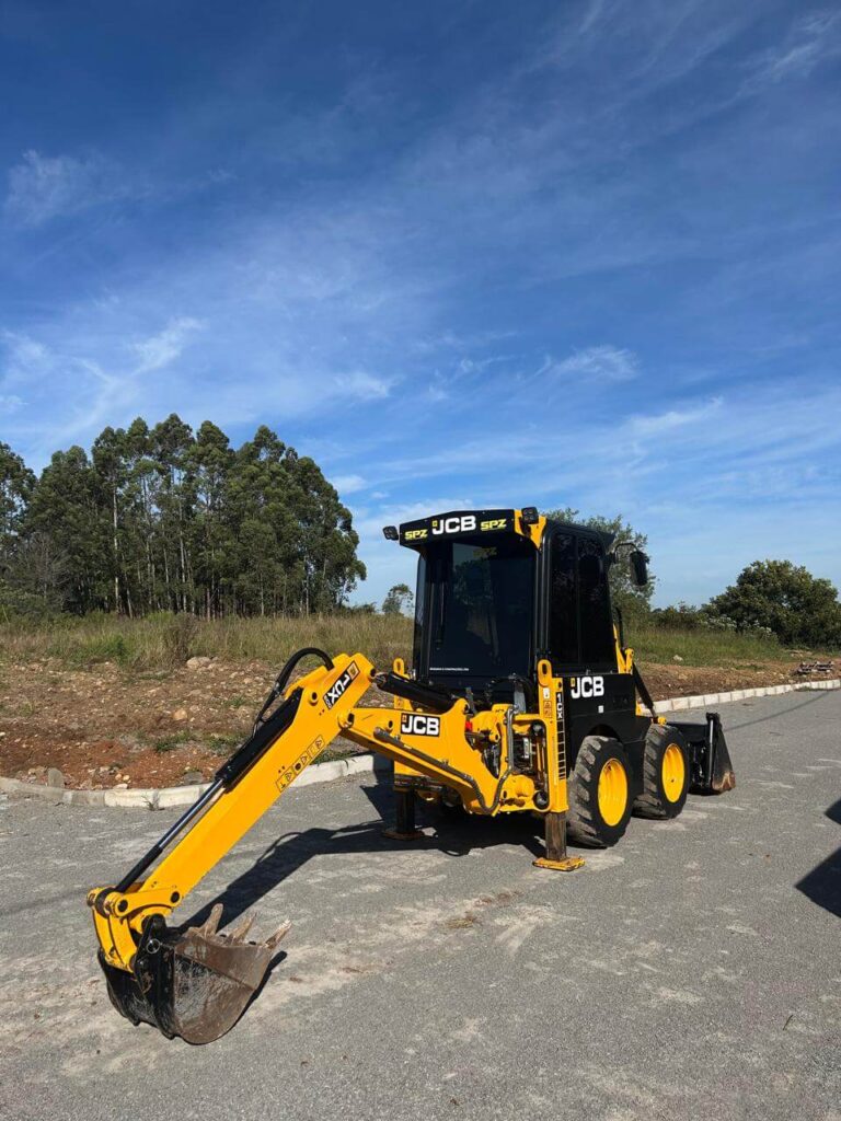 Rolo compactador Wacker Neuson RD12 estacionado sobre pavimento de blocos, sob céu azul.
